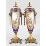 A GOOD PAIR OF 19TH CENTURY SEVRES PORCELAIN URNS AND COVERS, painted with reverse panels of