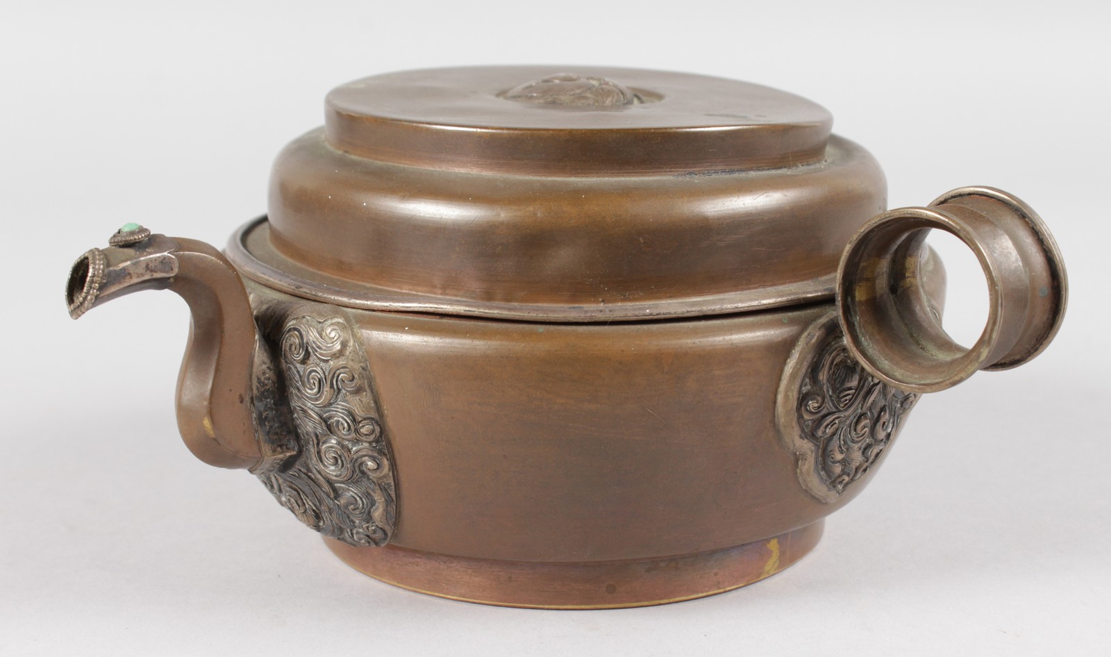 AN ISLAMIC CIRCULAR COPPER BOWL AND COVER with handle and pouring spout. 6ins diameter.