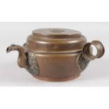 AN ISLAMIC CIRCULAR COPPER BOWL AND COVER with handle and pouring spout. 6ins diameter.