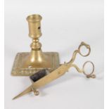 AN EARLY BRASS SQUARE BASE CANDLESTICK, 4ins high, and A CANDLE SNUFFER.