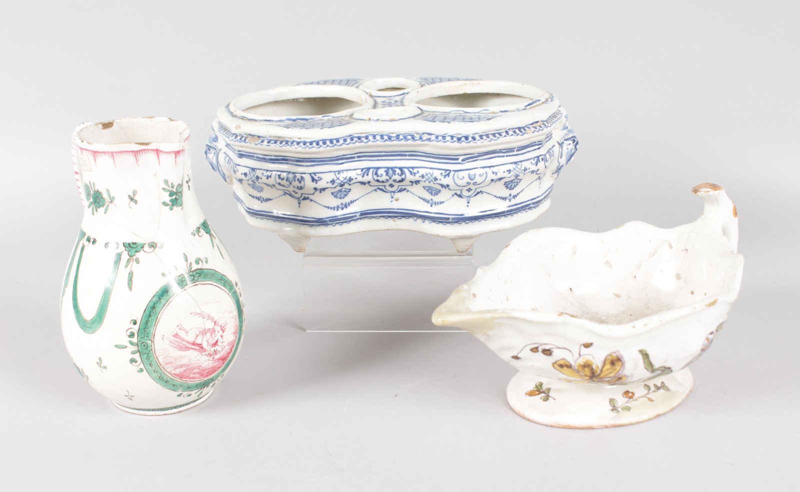 A FRENCH FAIENCE SAUCEBOAT, JUG AND CRUET STAND (3).