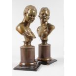 A RARE PAIR OF 19TH CENTURY BRONZES OF NEGRO BUSTS looking sideways, on pedestals with wooden bases.