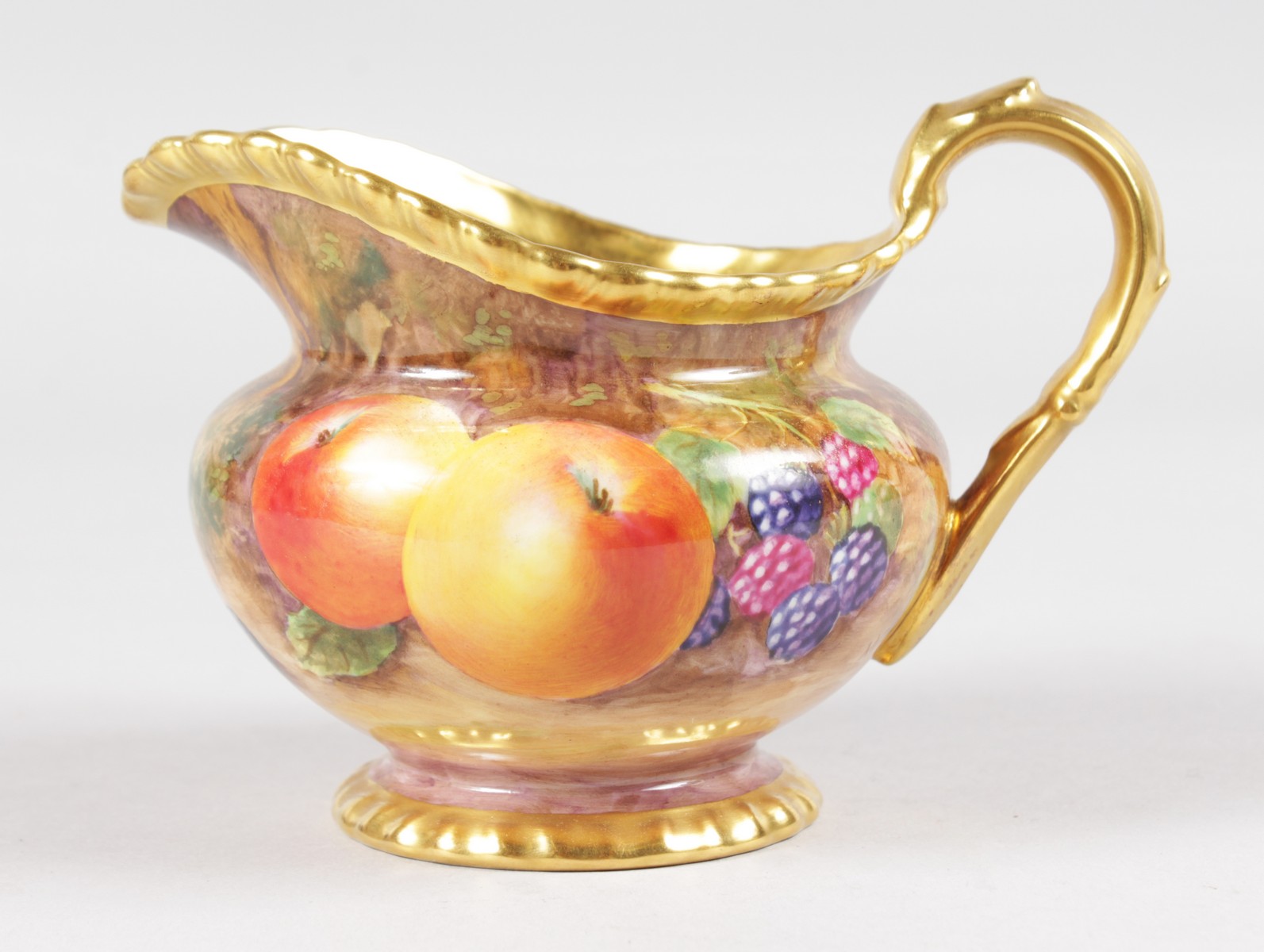 A ROYAL WORCESTER FRUIT PAINTED GADROON BORDERED CREAM JUG, signed by M. Tandy, black mark.