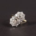 AN 18CT WHITE GOLD DIAMOND CROSSOVER CLUSTER RING.