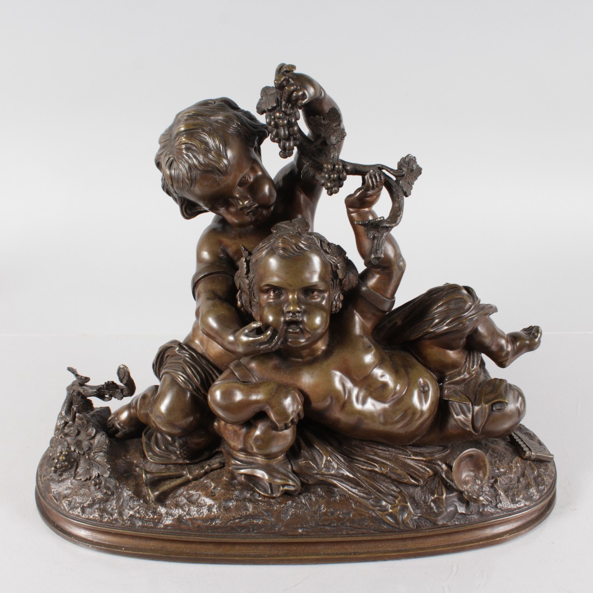 A GOOD 19TH CENTURY FRENCH BRONZE GROUP OF TWO YOUNG CUPIDS depicting harvest, holding grapes. 15ins