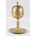 AN EARLY CONTINENTAL BRASS INCENSE BURNER with pierced hinged top and circular base. 9.5ins high.