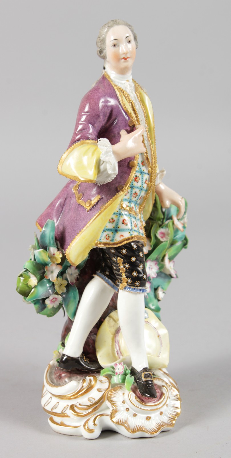 AN EARLY 19TH CENTURY FINE DERBY FIGURE OF A GALLANT standing beside a flowering plant in formal