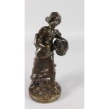 A 19TH CENTURY FRENCH BRONZE OF A YOUNG WOMAN carrying a basket of fruit and standing on a