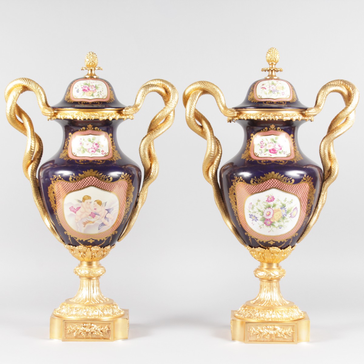 A SUPERB PAIR OF "SEVRES" BLUE PORCELAIN TWO HANDLED URNS AND COVERS, painted with reverse scenes,