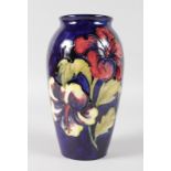 A MOORCROFT HIBISCUS PATTERNED VASE. Impressed MOORCROFT with printed label. 7.5ins high.