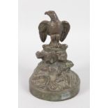A BRONZE EAGLE on a rock with circular base. Signed Morde. 5.5ins high.