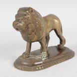 A BRONZE STANDING LION on an oval base. 5.5ins long.