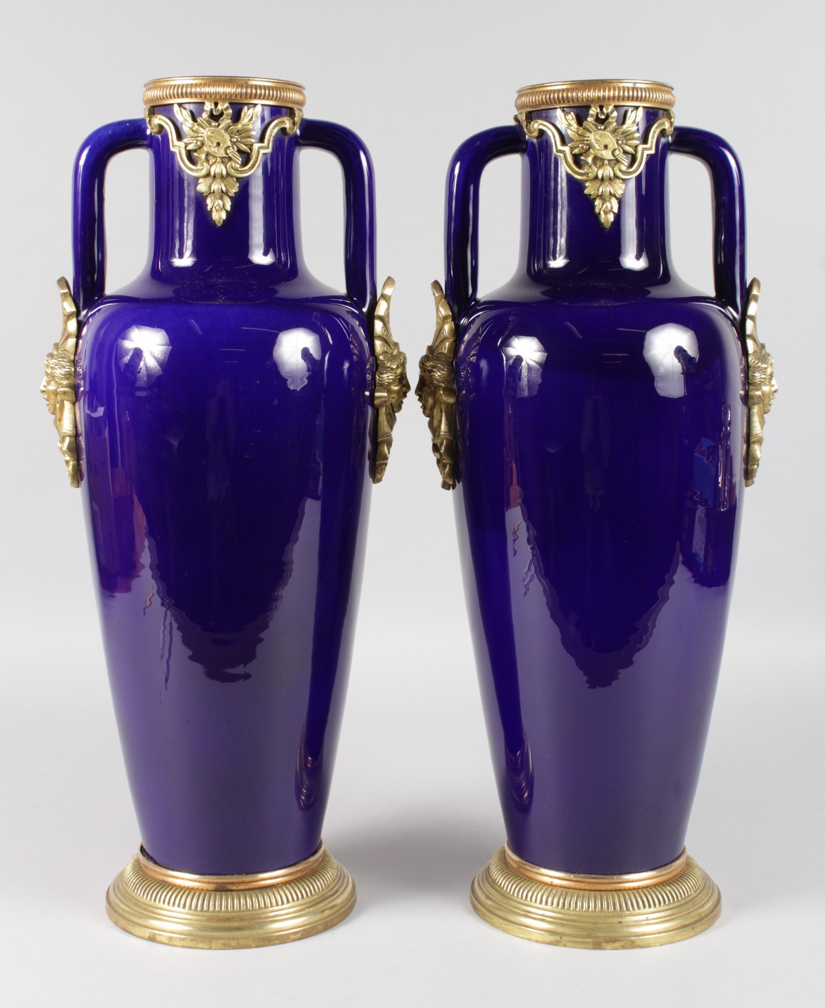 A GOOD PAIR OF SEVRES RICH BLUE PORCELAIN AND TWO HANDLED TAPERING VASES with gilt metal mounts