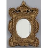 A 19TH/20TH CENTURY CHINESE GILT WOOD FRAMED MIRROR, the wood surround carved in deep relief with