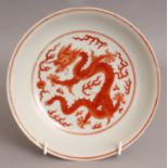 A CHINESE ROUGE-DE-FER PORCELAIN DRAGON DISH, of saucer shape, the base with a six-character