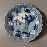 A CHINESE KANGXI PERIOD BLUE & WHITE PORCELAIN SAUCER, circa 1700, with a barbed-edge rim, painted