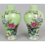A MIRROR PAIR OF GOOD QUALITY LIME GREEN GROUND SGRAFFIATO FAMILLE ROSE PORCELAIN VASES, each