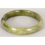 A CHINESE PALE SPINACH GREEN JADE BANGLE, 2.8in diameter, the inner rim 2.25in diameter.