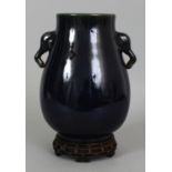 A CHINESE BLUE GLAZED PORCELAIN HU VASE, together with a fitted pierced wood stand, with moulded