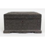 A 19TH CENTURY INDIAN SANDALWOOD RECTANGULAR BOX & COVER, carved overall in relief with scrolling
