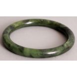 A CHINESE SPINACH GREEN JADE BANGLE, 3.25in diameter, the inner rim 2.4in diameter.