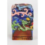 A CHINESE ENAMELLED GLASS SEAL, the sides and top surface decorated in relief with sinuous