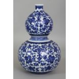 A CHINESE MING STYLE BLUE & WHITE DOUBLE GOURD PORCELAIN VASE, decorated with formal scrolling