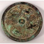 A SMALL CHINESE BRONZE MIRROR, possibly early, decorated in relief with birds and phoenix encircling