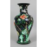 A LARGE FAMILLE NOIRE PORCELAIN VASE, decorated with a continuous garden scene, 19in high.