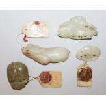 FOUR SMALL 19TH/20TH CENTURY CHINESE JADE CARVINGS, two with attached export seals, the longest 2.