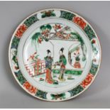 A CHINESE KANGXI PERIOD FAMILLE VERTE PORCELAIN PLATE, painted with two ladies in a garden terrace