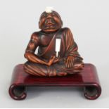 AN EARLY 20TH CENTURY SIGNED JAPANESE IVORY & HARDWOOD NETSUKE OF A SEATED SENNIN, of larger than