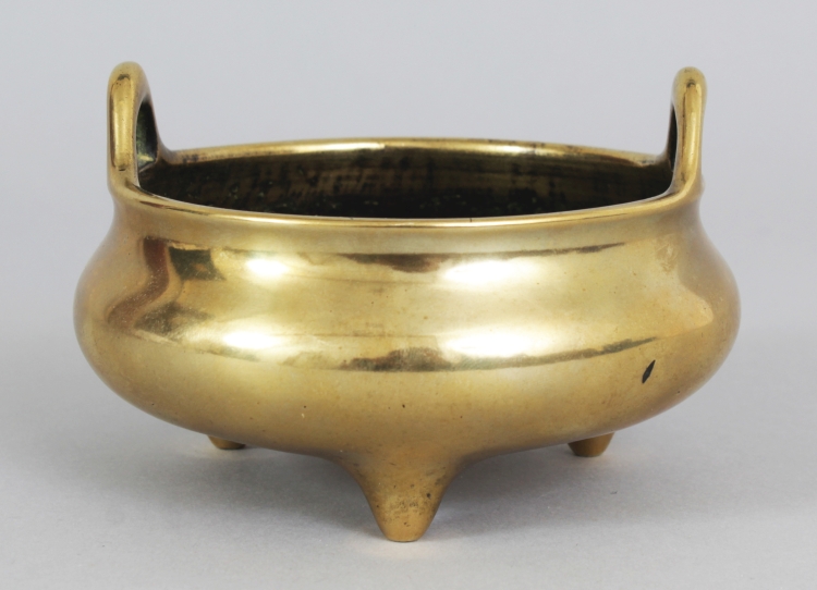 A 19TH CENTURY CHINESE POLISHED BRONZE TRIPOD CENSER, weighing 440gm, the rim with double upright
