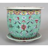 A 20TH CENTURY CHINESE TURQUOISE GROUND FAMILLE ROSE PORCELAIN JARDINIERE & STAND, the sides of