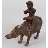 A 17TH CENTURY CHINESE LATE MING DYNASTY IRON MODEL OF A BOY ON A WATER BUFFALO, the boy seated