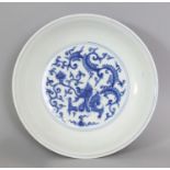 A CHINESE MING STYLE BLUE & WHITE PORCELAIN SAUCER DISH, decorated with stylised dragons and