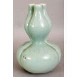 A CHINESE DOUBLE GOURD CELADON PORCELAIN VASE, with an unusual triple neck, the sides lobed, the