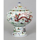 A CHINESE MING STYLE DOUCAI PORCELAIN JAR & COVER, supported on a tall splayed foot, the sides