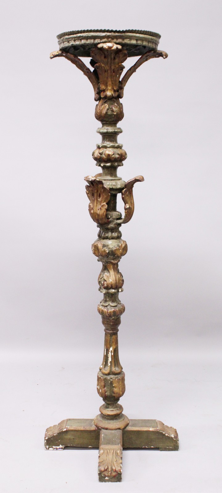 AN EARLY CARVED AND PAINTED PRICKET FLOOR STANDING CANDLESTICK, with circular top, leaf carved