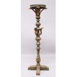 AN EARLY CARVED AND PAINTED PRICKET FLOOR STANDING CANDLESTICK, with circular top, leaf carved