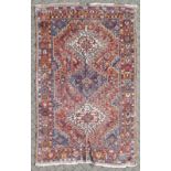 A PERSIAN RUG, claret and blue ground, within a double border. 9ft 5ins x 5ft 9ins.