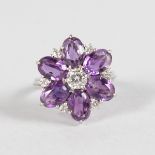 A NICE AMETHYST AND DIAMOND FLOWER HEAD CLUSTER RING set in 18ct white gold.