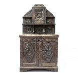 A 17TH CENTURY STYLE CARVED OAK SMALL DRESSER, 19TH CENTURY, the upper section with a small door and