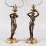 A PAIR OF 19TH CENTURY FRENCH LAMPS of NUDE YOUNG LADIES holding light fittings, on a circular base.