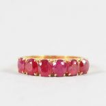 A SIX STONE HALF HOOP RUBY RING set in 22ct yellow gold.