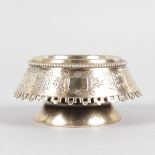A SMALL RUSSIAN CIRCULAR SILVER GILT SALT, engraved with calligraphy, on a pedestal base. 7cms