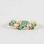 A DIAMOND AND EMERALD RING set in 18ct yellow gold.