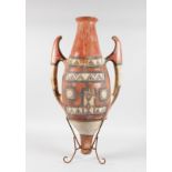 AN AMPHORA on a metal stand with red ground geometric design. 2ft 4ins high.