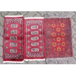 THREE SMALL PRAYER RUGS, red ground, within single borders, largest 2ft x 1ft 5ins; together with