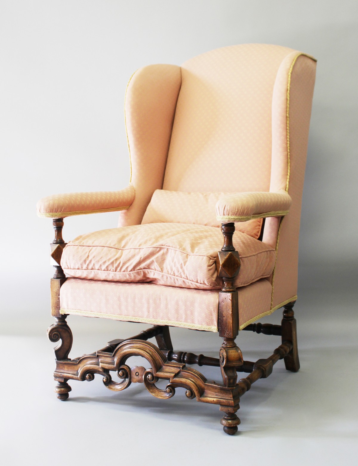 A QUEEN ANNE STYLE UPHOLSTERED WING ARMCHAIR, 20TH CENTURY, with rounded top, padded arms, on turned